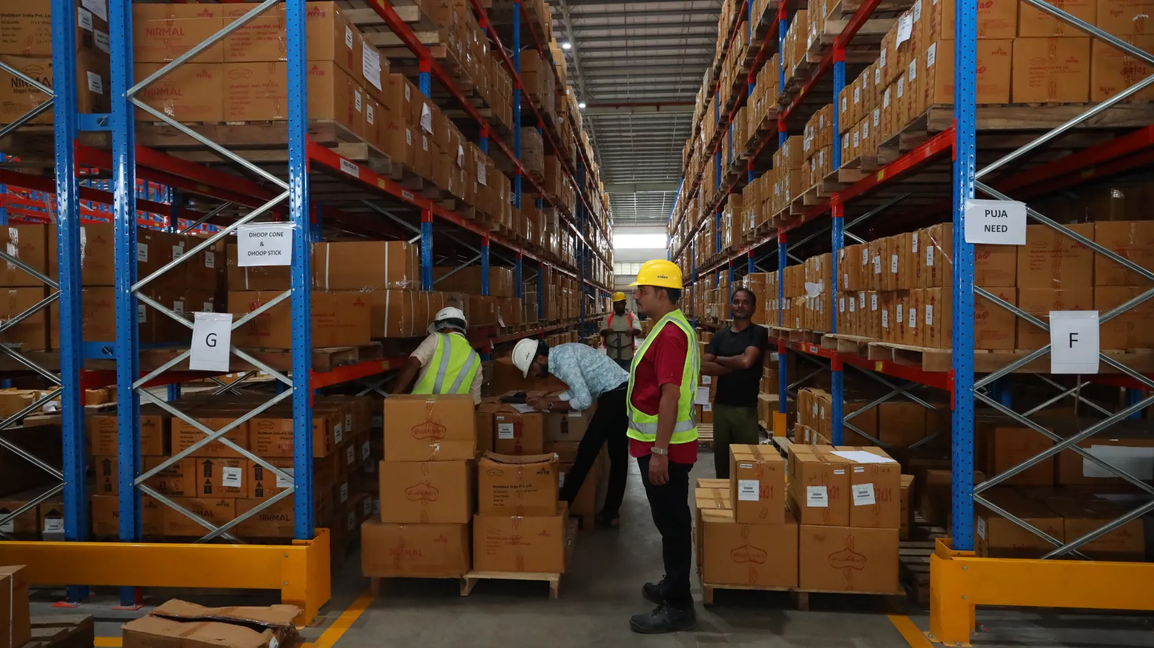 Warehouse staff in safety gear managing stock at a Pittie Group facility