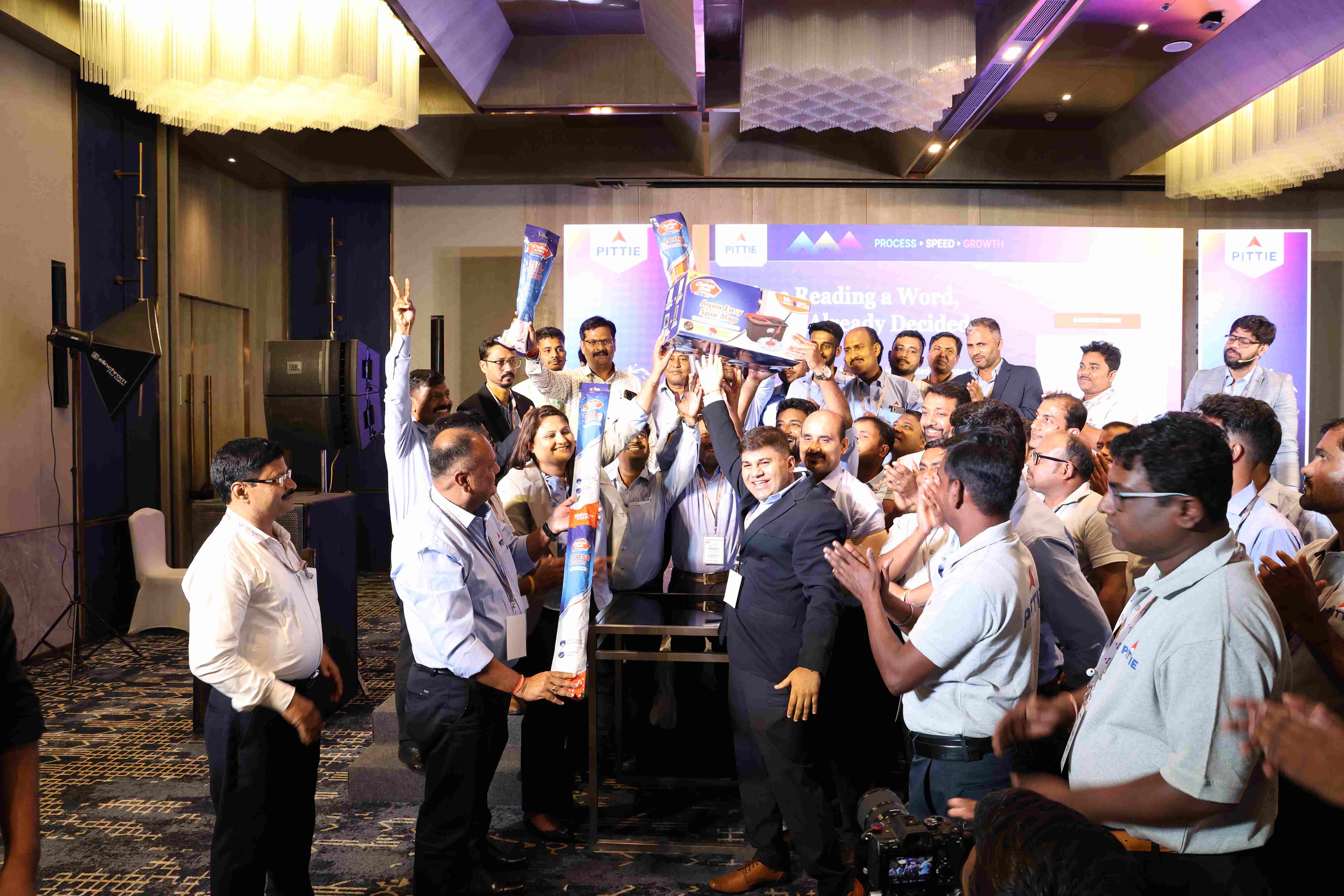 Employees celebrating an achievement on stage at a Pittie Group event